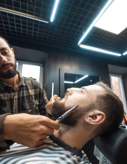 hairdresser-doing-haircut-of-beard-using-comb-and-2021-12-09-22-33-26-utc.jpg